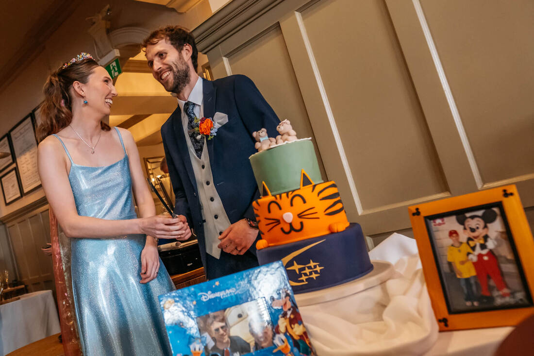 The cake cutting ceremony at Bishops Gate Hotel was a moment of joyous celebration for the Bride and Groom, surrounded by friends and family after their Guildhall wedding in Derry.